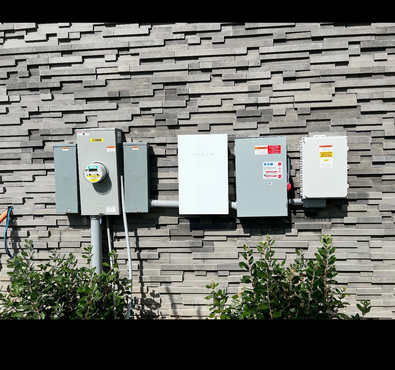 Tesla Powerwall and electrical equipment on an exterior wall